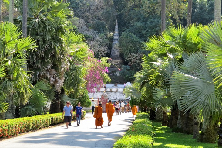 Monges e turistas caminhando pelos jardins do complexo